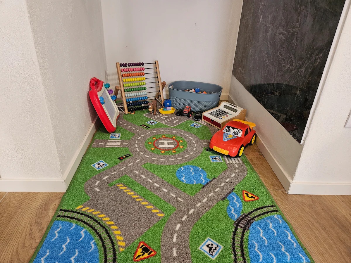 Angolo giochi per bambini con tappeto e giocattoli
