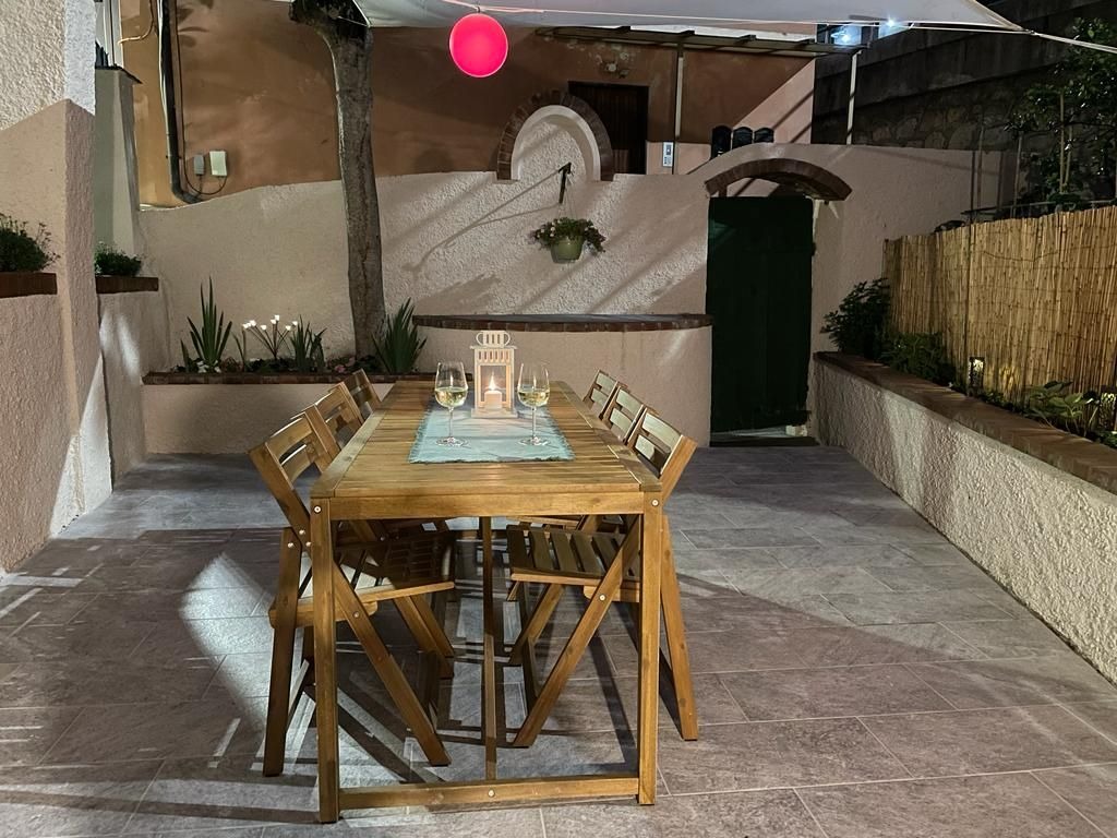 Cortile con tavolo da pranzo esterno illuminato la sera