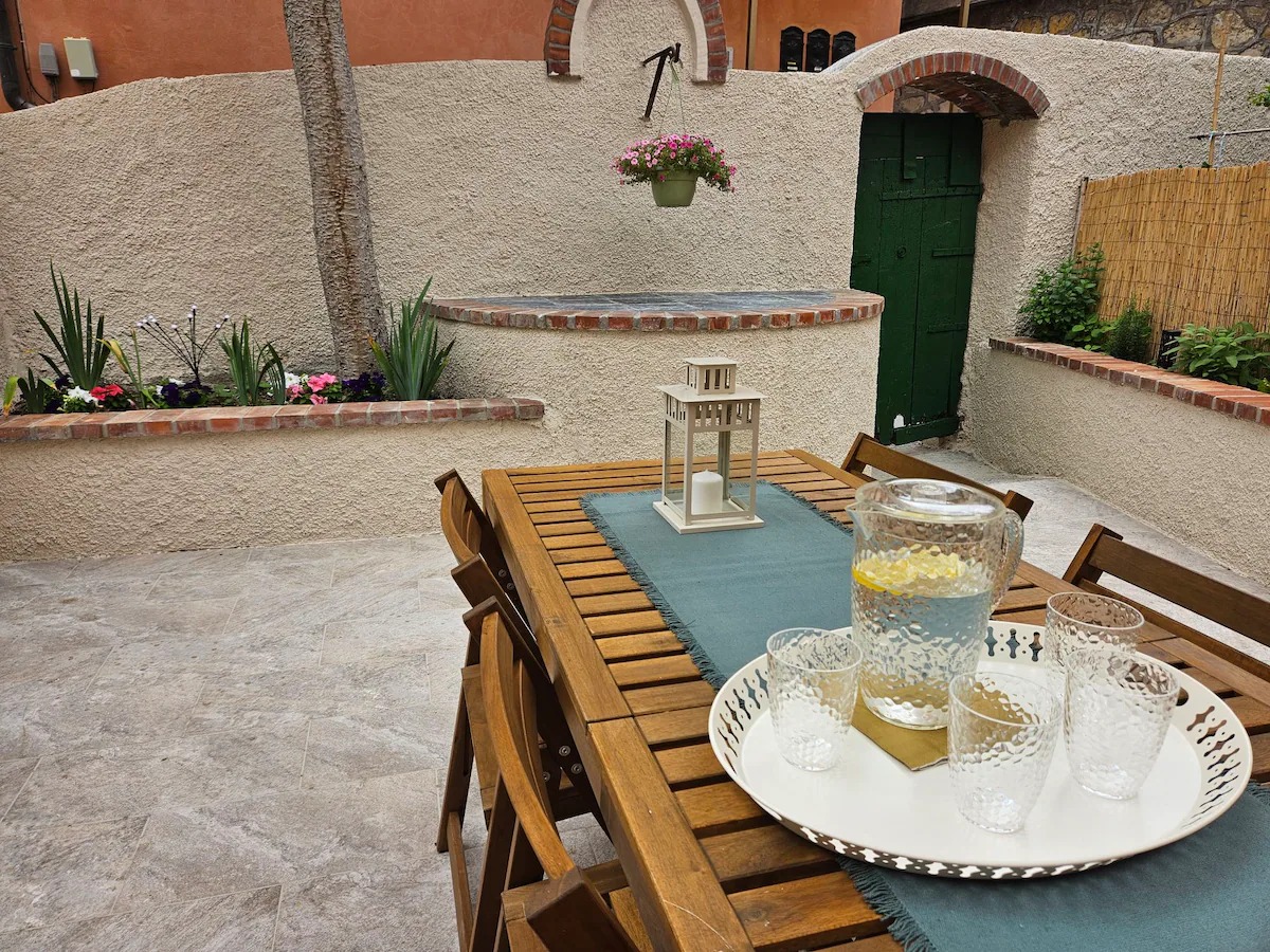 Tavolo esterno con caraffa d'acqua e lanterna nel cortile