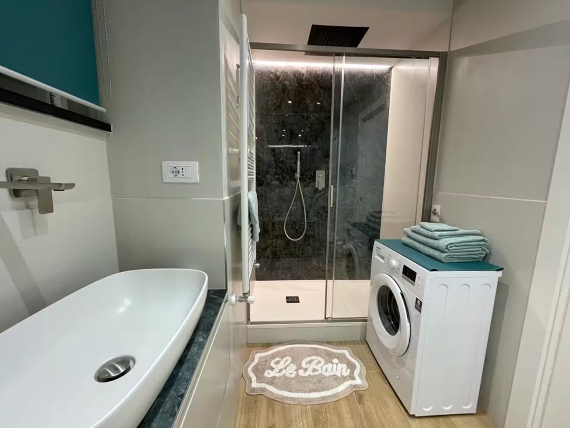 Bagno con doccia, lavabo e lavatrice