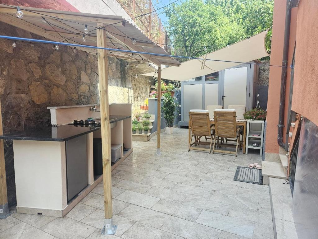 Cortile con pergola, tavolo e cucina esterna