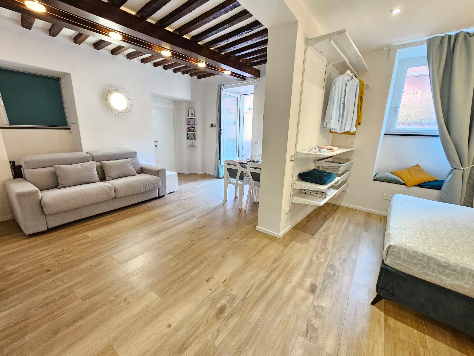 Open space con divano letto, cabina armadio e letto