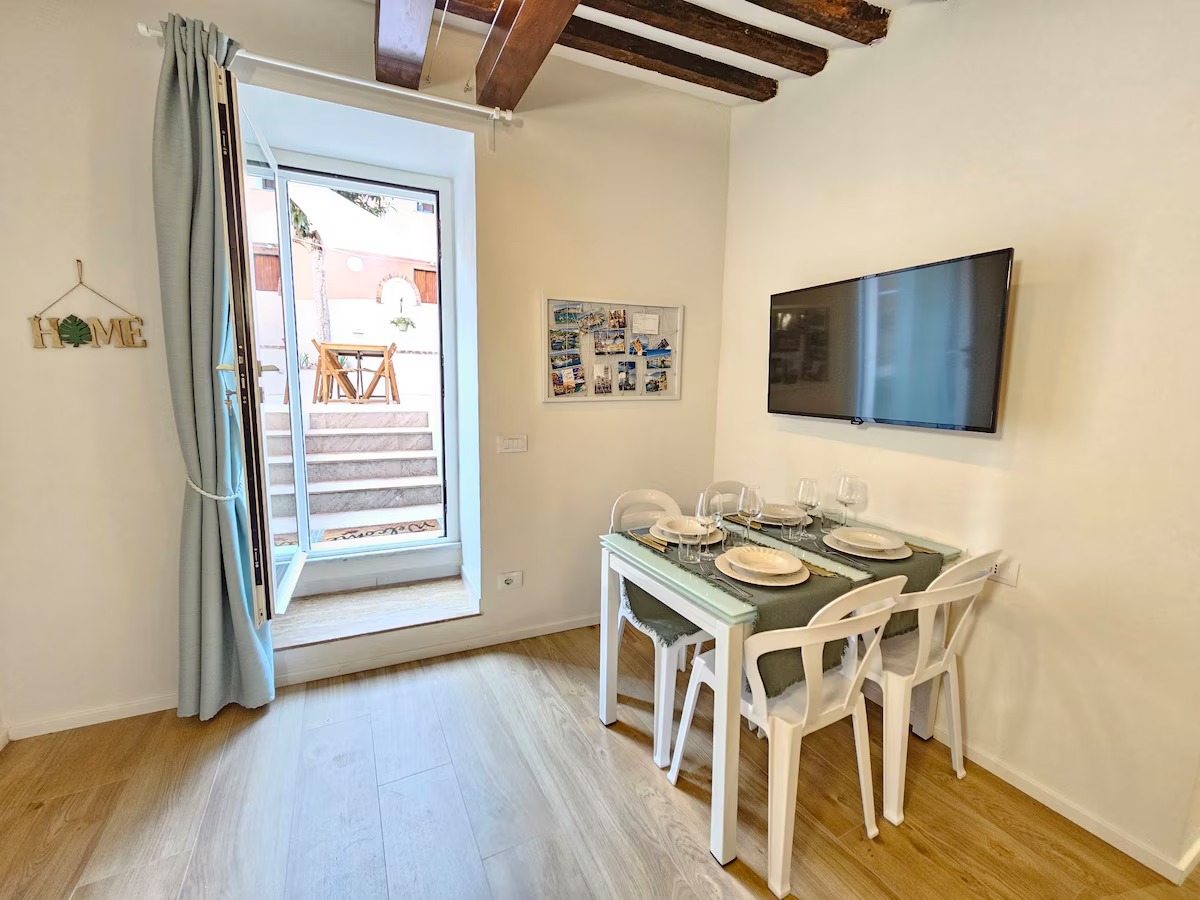 Zona pranzo con TV e porta finestra sul cortile