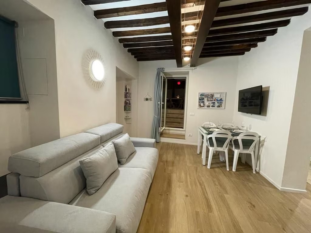 Soggiorno con divano, TV e zona pranzo