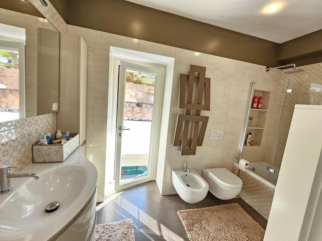 Bagno con doccia, bidet e finestra